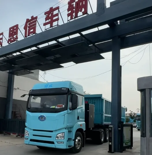 A fleet of brand new Enxin 3 axle rear dump semi trailers driving through the factory gate for port delivery