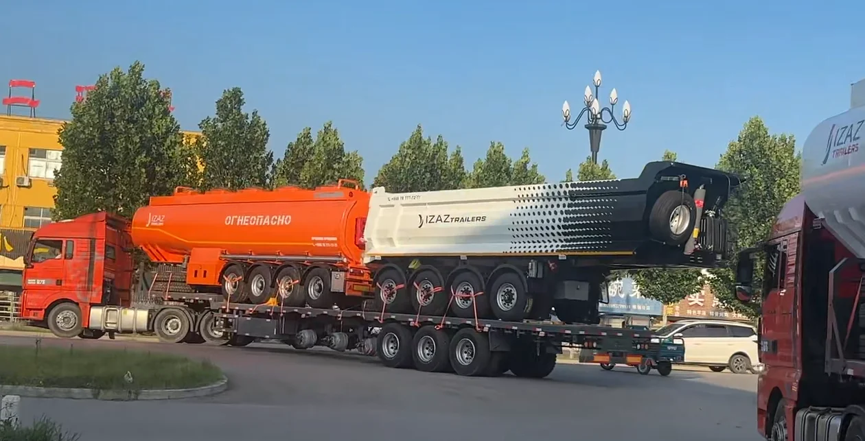 A fleet of red Enxin 3 axle rear dump semi trailers preparing for export to Uzbekistan.